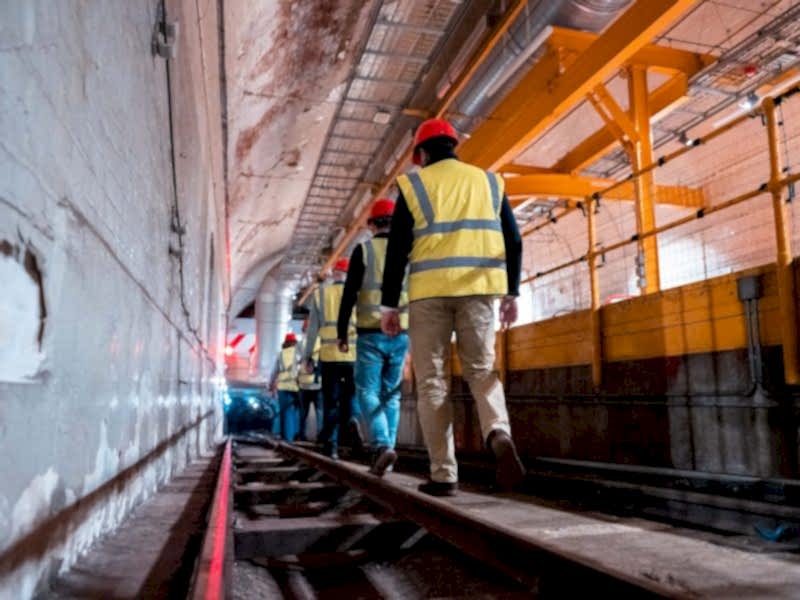 We can see the tour attendees descending down the Mail Rail tunnel, wearing their protective gear.
