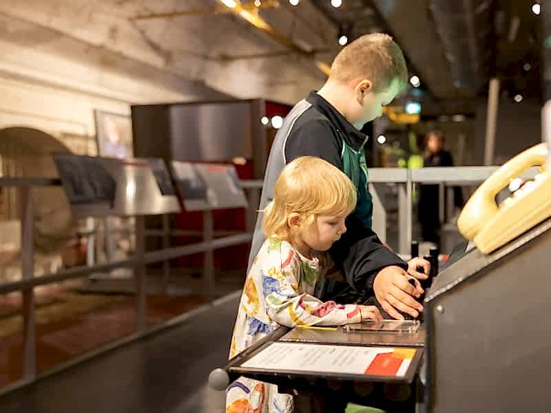 Two young children playing with an interactive exhibition.