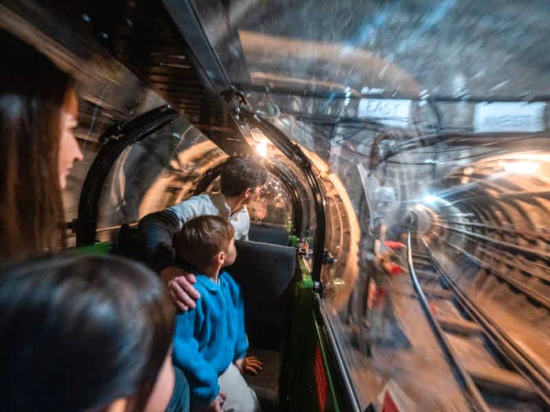 This slightly blurry image gives you a feel for the experience riding Mail Rail. The child and parent passengers look in awe at the dimly-lit Mail Rail tunnels.